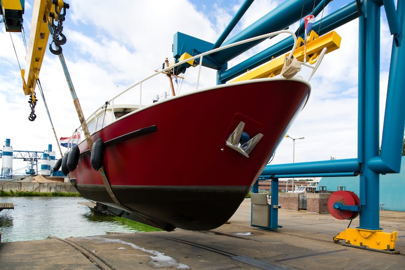 bigstock-Boat-crane-lifting-a-motorboat-256705390